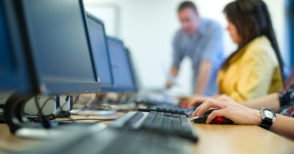 Hands on a keyboard during a computer skills class.